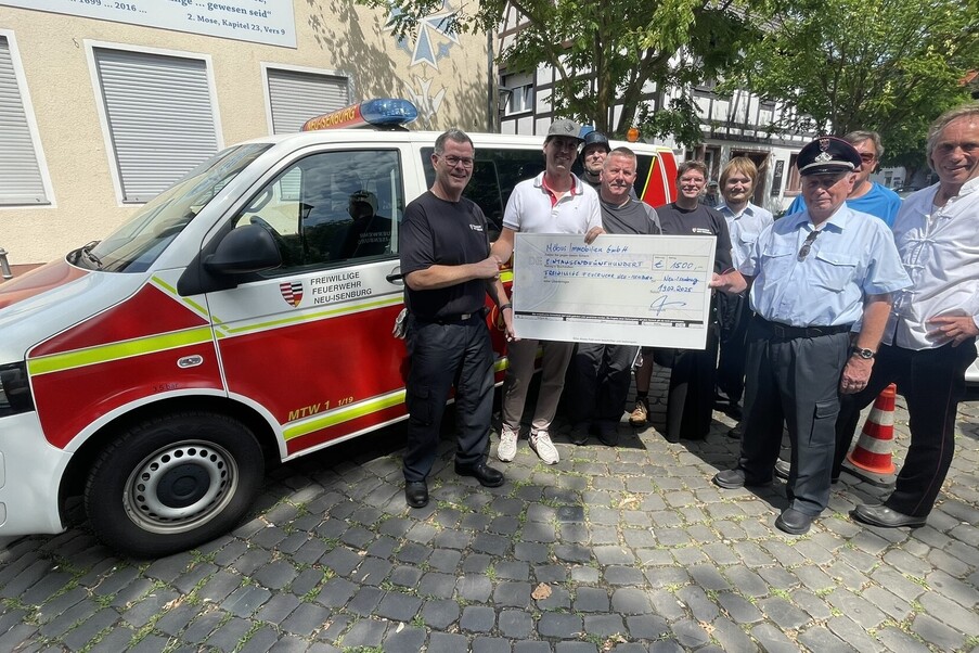 Übergabe auf dem Marktplatz: Wehrführer Jens Multer (links) nimmt den symbolischen Scheck von Dennis Möbus entgegen. Mit im Bild: (von links nach rechts): Frank Burger, Stephan Anthes, Carsten Petz, Sven Schluckebier, Karlheinz Müller, Martin Baumann und Peter Kröcker